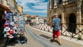 Tourists pass souvenir shops next to the Arenes d`Arles, Roman Amphitheater