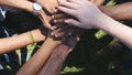 Arm of all races and colors stacked together one by one in unity and teamwork and then raised. Many multiracial hands Royalty Free Stock Photo