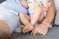 Anonymous dad on couch with baby daughter Royalty Free Stock Photo