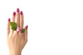 Female hand with pink nail polish and flowers between the fingers