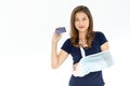 Arm broken beautiful Asian woman with arm sling showing and using credit card. Studio shot white background. Concept for expense Royalty Free Stock Photo