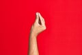 Arm of caucasian white young man over red isolated background doing italian gesture with fingers together, communication gesture Royalty Free Stock Photo