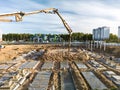 Arm of concrete pump ready for concrete conveying at construction site. Jib of concrete pump truck against sky at background. Royalty Free Stock Photo