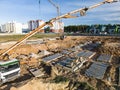 Arm of concrete pump ready for concrete conveying at construction site. Jib of concrete pump truck against sky at background. Royalty Free Stock Photo