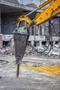 Arm of excavator with hydraulic breaker hammer for the destruction of concrete and hard rock at the construction site. Royalty Free Stock Photo