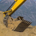 Arm of extractor scooping up dirt on a sunny day Royalty Free Stock Photo