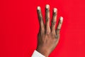 Arm and hand of african american black young man over red isolated background counting number 4 showing four fingers Royalty Free Stock Photo