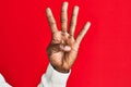 Arm and hand of african american black young man over red isolated background counting number 4 showing four fingers Royalty Free Stock Photo