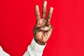 Arm and hand of african american black young man over red isolated background counting number 3 showing three fingers Royalty Free Stock Photo