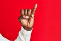 Arm and hand of african american black young man over red isolated background showing little finger as pinky promise commitment, Royalty Free Stock Photo