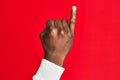 Arm and hand of african american black young man over red isolated background showing little finger as pinky promise commitment, Royalty Free Stock Photo
