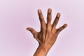 Arm and hand of black middle age woman over pink isolated background counting number 5 showing five fingers Royalty Free Stock Photo