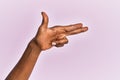 Arm and hand of black middle age woman over pink isolated background gesturing fire gun weapon with fingers, aiming shoot symbol Royalty Free Stock Photo