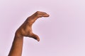 Arm and hand of black middle age woman over pink isolated background picking and taking invisible thing, holding object with Royalty Free Stock Photo