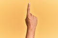 Arm and hand of caucasian man over yellow isolated background counting number one using index finger, showing idea and Royalty Free Stock Photo
