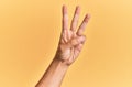 Arm and hand of caucasian man over yellow isolated background counting number 3 showing three fingers Royalty Free Stock Photo