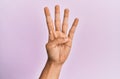 Arm and hand of caucasian young man over pink isolated background counting number 4 showing four fingers Royalty Free Stock Photo