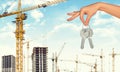 Arm holding keys on construction site background Royalty Free Stock Photo