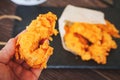 arm and meat strips on a black tray. strips of meat fried in breading. Royalty Free Stock Photo