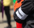 Arm of a person with a black jacket, on which a white bandage with the German inscription Royalty Free Stock Photo