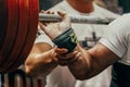 arm powerlifter in wrist wraps to hold heavy barbell