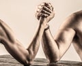 Arms wrestling thin hand, big strong arm in studio. Two man& x27;s hands clasped arm wrestling, strong and weak, unequal