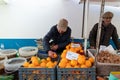 Local fruit sellers and fresh oranges at market stall in Armacao de Pera