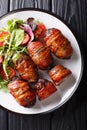 Armadillo eggs are a classic Texas BBQ staple served with salad close up on a plate. Vertical top view Royalty Free Stock Photo