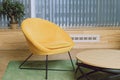 Armchair without armrests and a low coffee table in the waiting area of the office Royalty Free Stock Photo