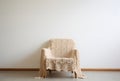 Armchair covered with crochet blanket in a room with a white wall