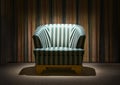 Armchair standing in a dark room with striped curtains under light of a lamp Royalty Free Stock Photo