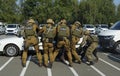 Armed men in uniform aiming guns to another men lying on the ground - soldiers of KORD, Ukrainian police strike force, performing