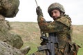 Armed military alpinist hanging on rope