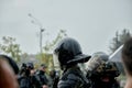 Armed police stand to disperse protesters in the rain