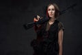 Armed with rifle attractive woman in dark background Royalty Free Stock Photo