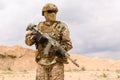 Soldier in camouflage holding rifle in the desert