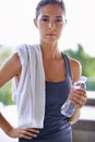 Armed with water for her workout. Portrait of an attractive young woman relaxing after a workout. Royalty Free Stock Photo