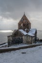Armenia, Lake Sevan - January 9, 2026: Stone church of Sevanavank Monastery stands on snowy plateau above lake, dark Royalty Free Stock Photo