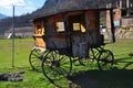 A wooden coach on a bright sunny day amidst mountains and green meadow Royalty Free Stock Photo