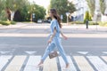 An Armenian brunette girl in elegant blue clothes crosses the road at a zebra crossing Royalty Free Stock Photo