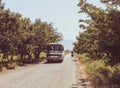 Armenian bus and a guy in a bike in a small road without fence and trees