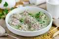 Armenian white sour soup with meatballs, bulgur and green parsley