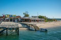 Armona Island in Algarve, Portugal. Beach with wooden jetty, boats and restaurant