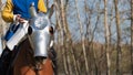 Armored Warhorse wearing chanfron on it`s muzzle and medieval knight without head on horseback