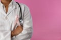 arms crossed nurse wearing breast cancer awareness pink ribbon Royalty Free Stock Photo