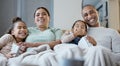 Arms for me to hold them. a happy family eating popcorn while watching television together at home. Royalty Free Stock Photo