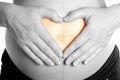 Arms on pregnant mommy belly tummy heart shape Royalty Free Stock Photo