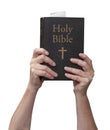 Arms raised into the air with hands reaching up and holding the Holy Bible book Royalty Free Stock Photo