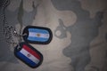 army blank, dog tag with flag of argentina and paraguay on the khaki texture background.