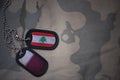 army blank, dog tag with flag of lebanon and qatar on the khaki texture background.